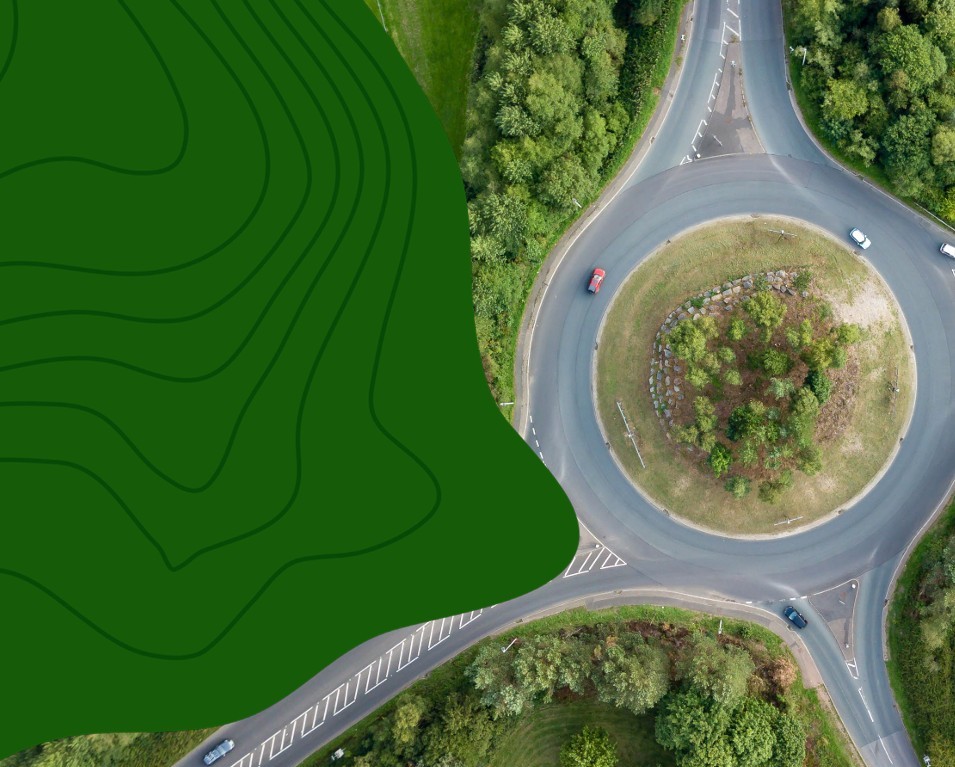 Picture of a roundabout from above with cars going around it. 