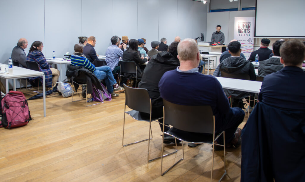 An audience of people listening at a festival event